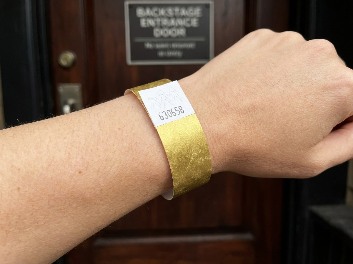 VIP festivalarmband met gouden metallic bedrukking en streepjescode, gedragen om een pols voor een backstage ingang